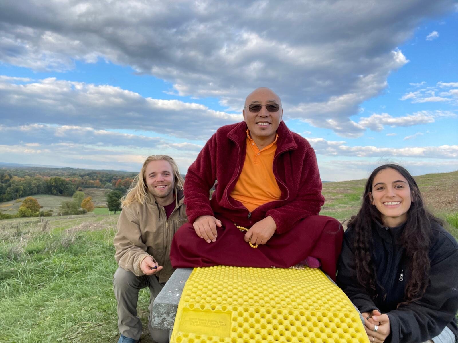 A teacher and community members gathered on a hillside