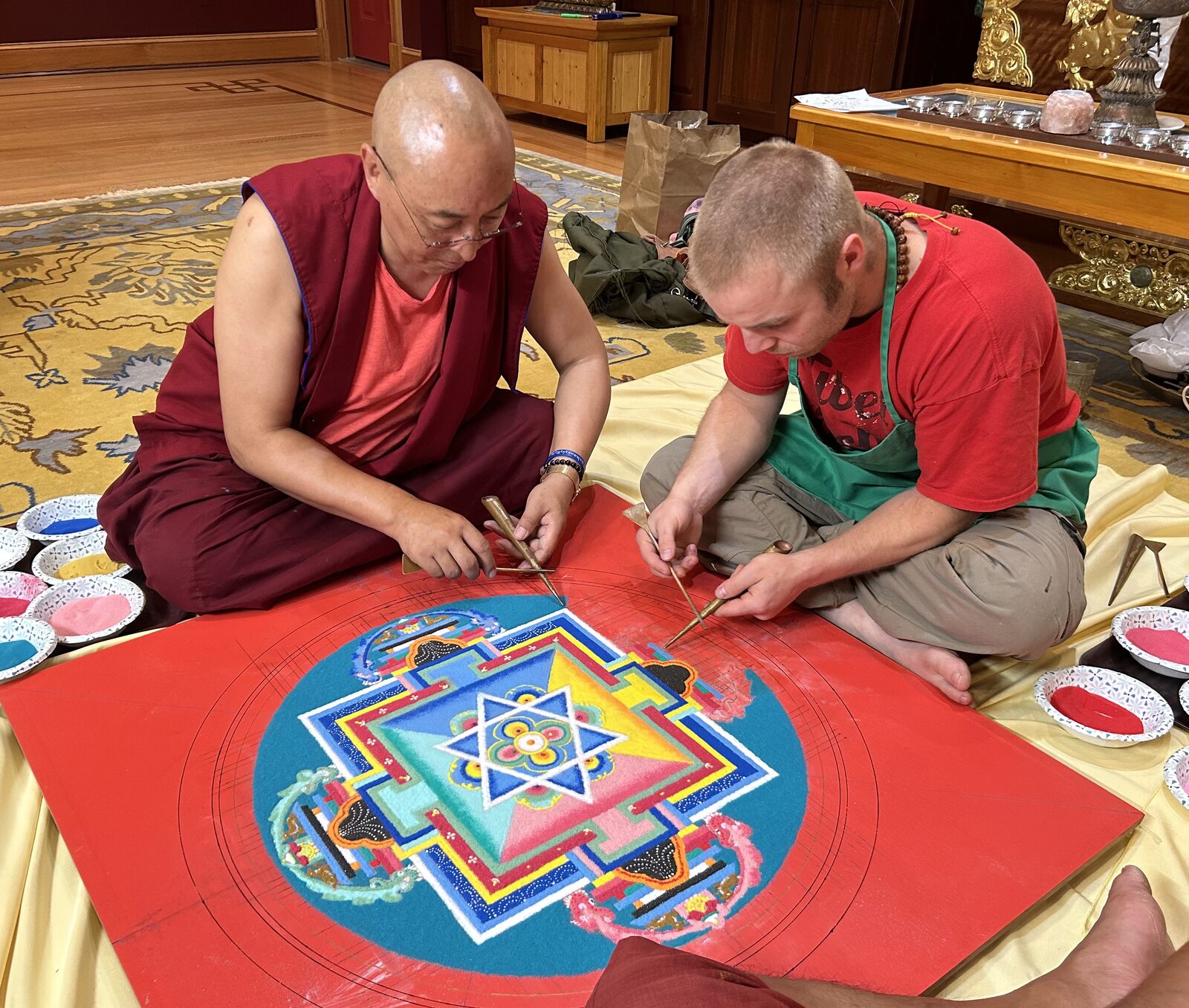 Davis constructing a sand mandala with his teacher